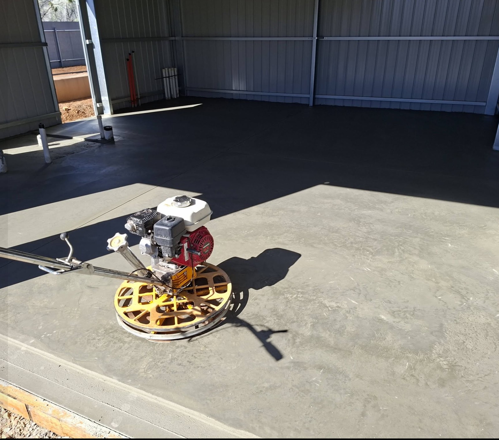 Machine-burnished concrete shed slab by Inca Concreting, power trowel finishing the surface
