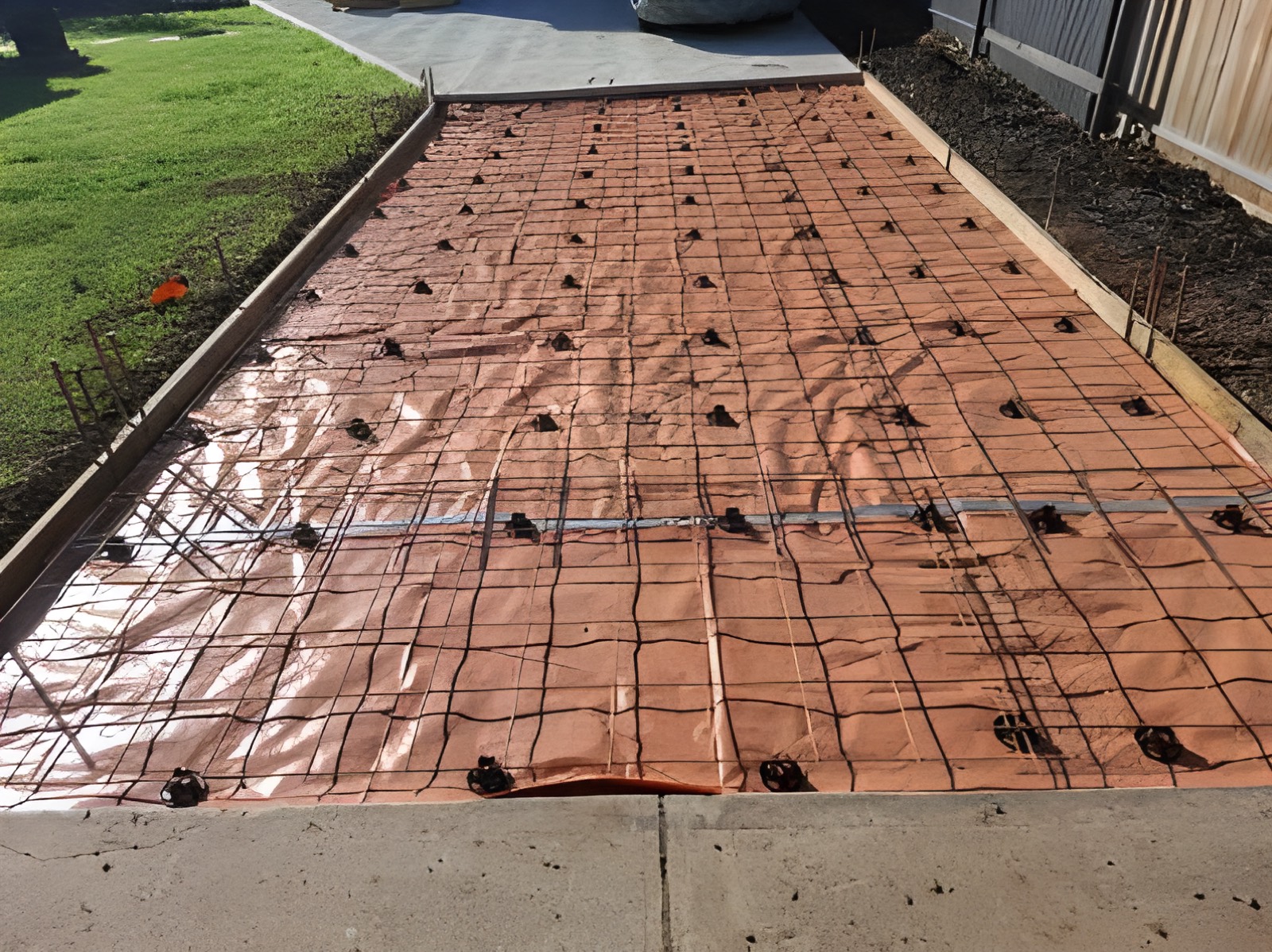 Driveway extension formed up with membrane and steel mesh beside a lawn