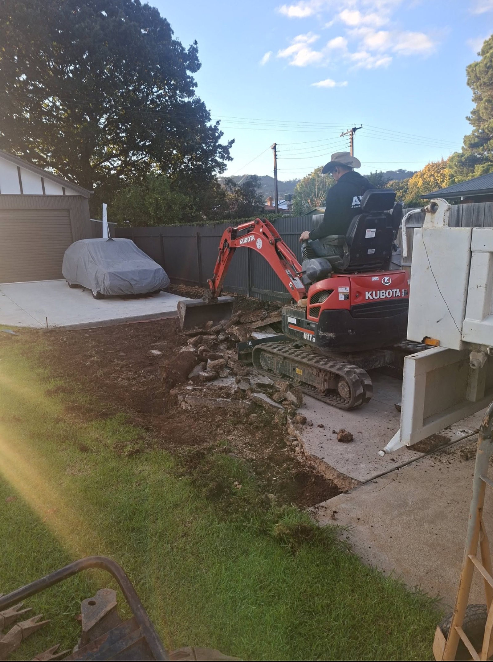 Kubota excavator removing an old concrete driveway