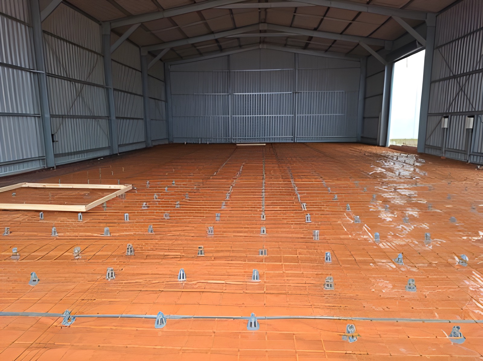Large industrial shed floor prepared with moisture membrane and steel mesh