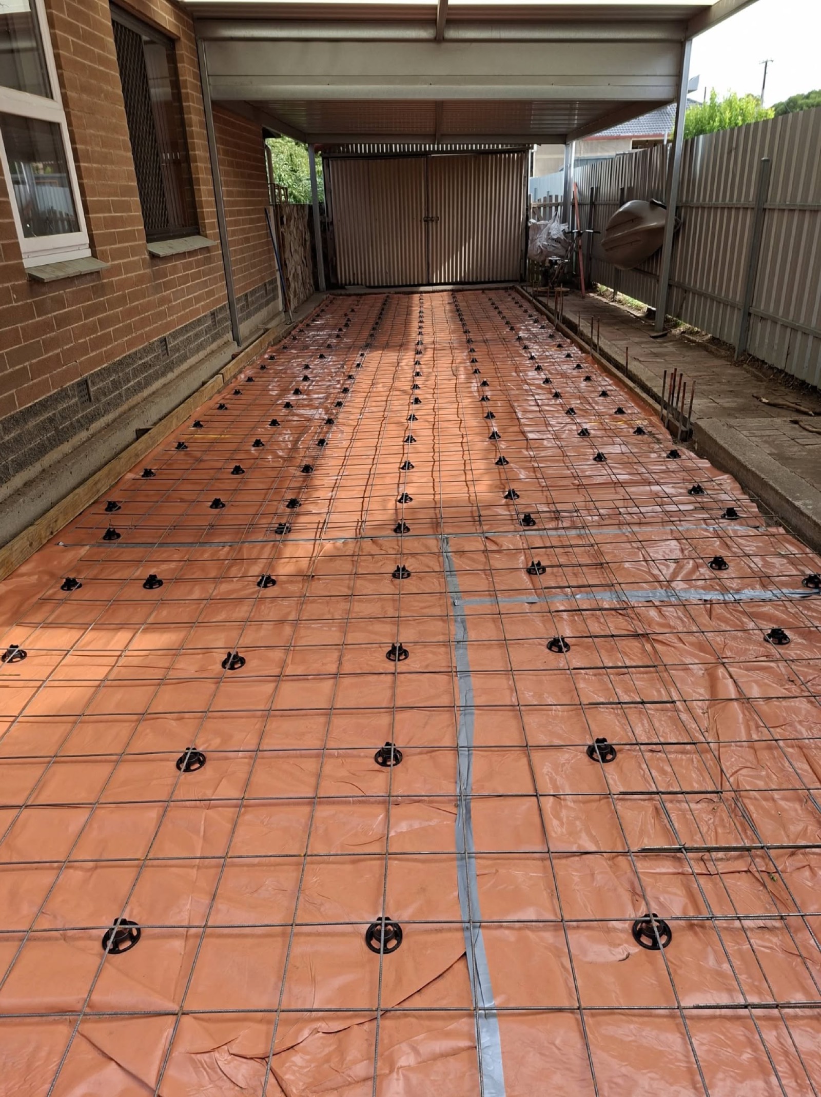 Steel mesh and moisture membrane preparation before a carport slab pour