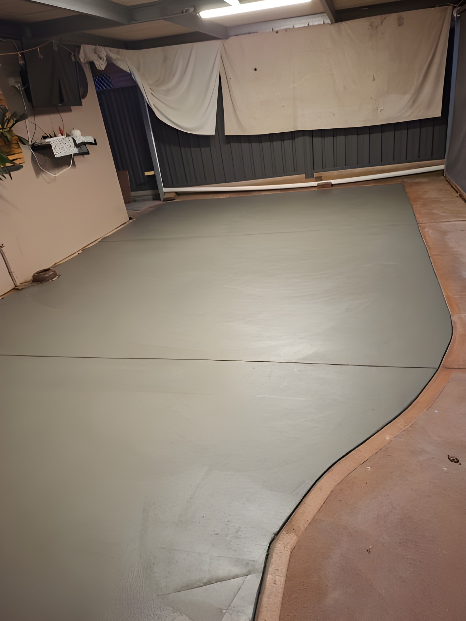 Freeform backyard patio slab with a curved edge, freshly finished